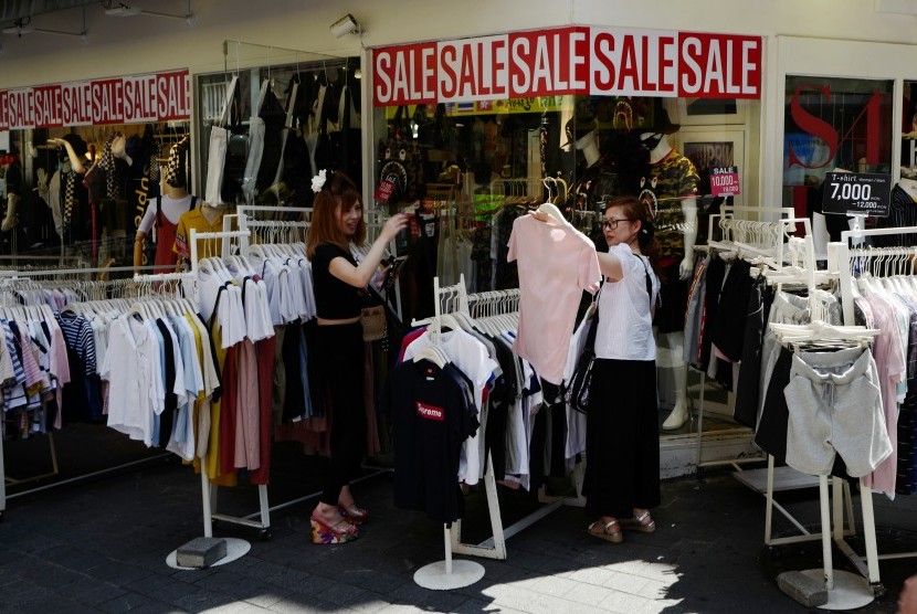 Pengunjung melihat-lihat pakaian yang dijual di kawasan Myeong-dong, Seoul, Korea Selatan.