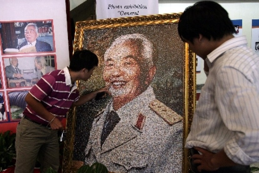 Pengunjung melihat lukisan pahlawan legendaris Vietnam Vo Nguyen Giap