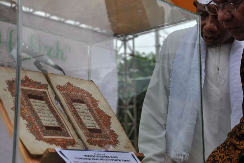 Pengunjung melihat mushaf Alquran kuno iluminasi khas Melayu Pantai Timur di Medan, Sumatera Utara, Kamis (4/10).
