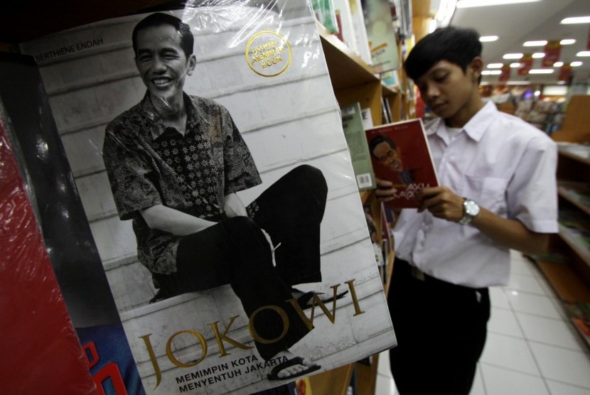 Pengunjung membaca buku tentang Jokowi di salah satu toko buku di Tangerang, Banten, Selasa (18/8).