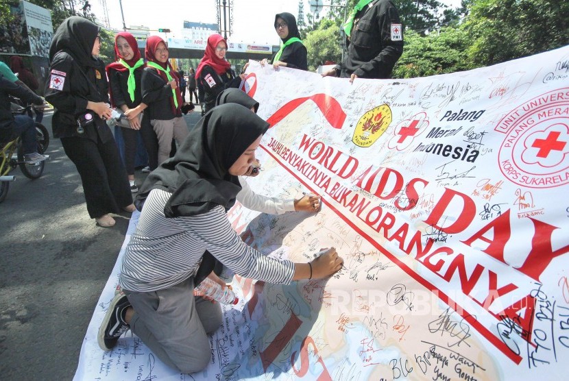 Pengunjung membubuhkan tandatangan dan menuliskan pesan-pesan di spanduk pada Peringatan hari Aids Sedunia, di Car Free Day, Jalan Ir H Djuanda, Kota Bandung. Walkot Yana Mulyana sebut jumlah kasus HIV-AIDS di Bandung bisa lebih besar dari data.