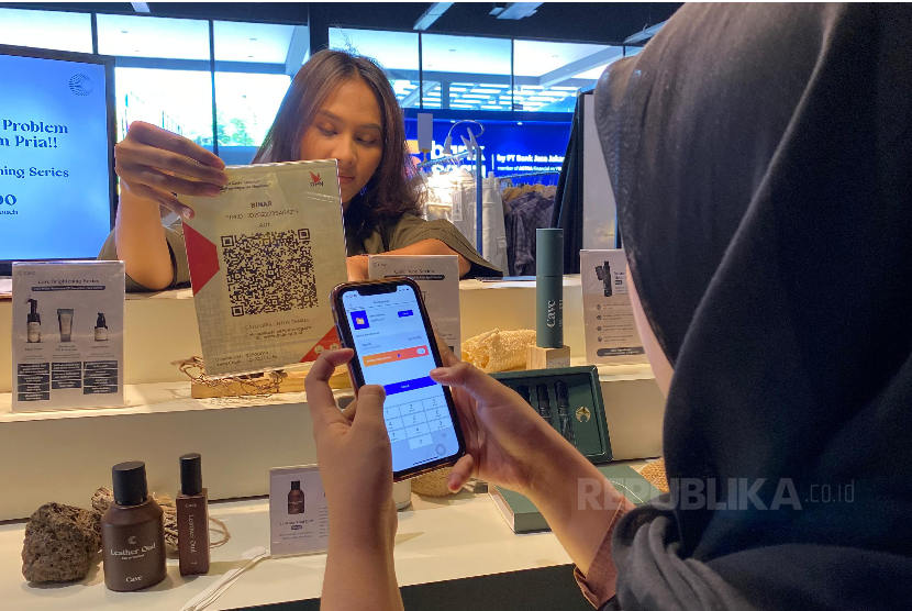 Pengunjung melakukan pembayaran menggunakan fasilitas QRIS dari sebuah bank digital di Jakarta, Jumat (8/11/2023). 