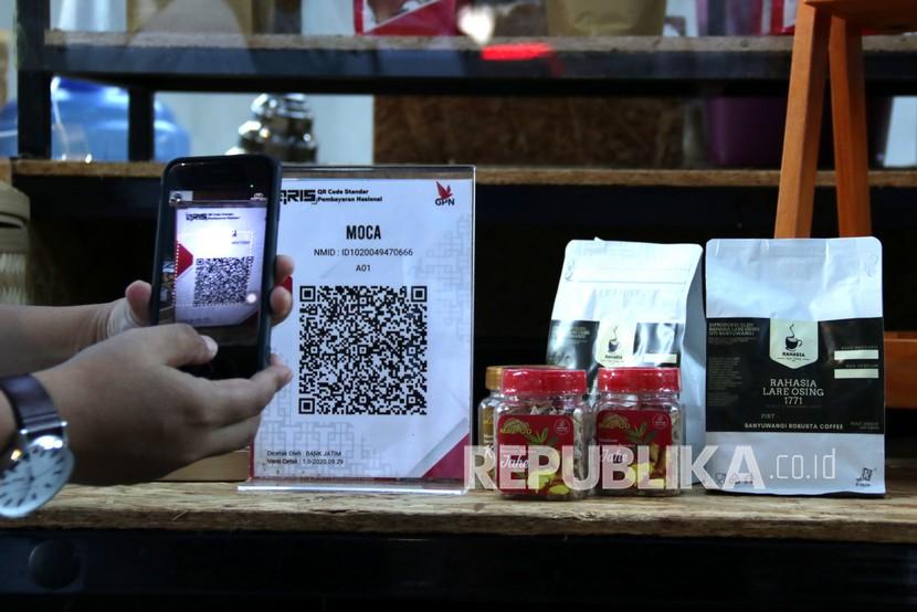 Pengunjung memindai kode batang pembayaran non tunai di Pasar takjil Banyuwangi, Jawa Timur. Penerapan pembayaran non tunai di pasar takjil itu sebagai upaya digitalisasi transaksi sektor UMKM di wilayah setempat. 