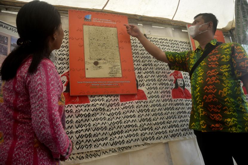 Pengunjung memperhatikan karya seni batik dengan menggunakan aksara 