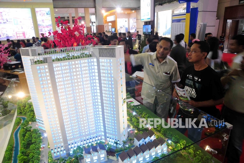 Pengunjung memperhatikan miniatur gedung apartemen saat pameran properti di Jakarta Convention Center (JCC) Jakarta, Ahad (14/2).