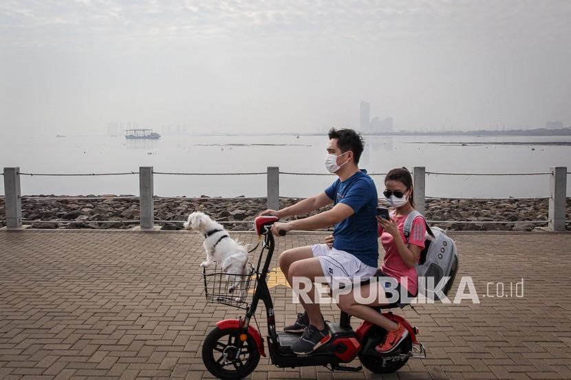 Pengunjung menaiki sepeda listrik usai berolahraga di kawasan Pantai Maju, Jakarta Utara. Fitness Specialist sarankan berolahraga pagi atau sore dengan jangka waktu 30 menit