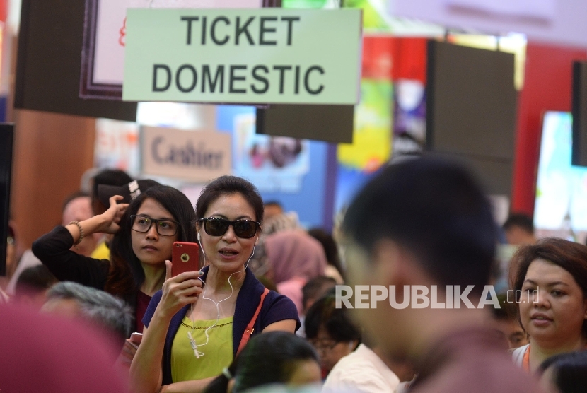 Pengunjung mencari info pemesanan tiket pada pameran Garuda Indonesia Travel Fair (GATF) di Jakarta Convention Centre, Jakarta, Jumat (22/9).