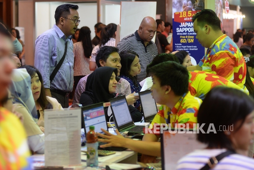 Pengunjung mencari info pemesanan tiket pada pameran Garuda Indonesia Travel Fair (GATF) di Jakarta Convention Centre, Jakarta, Jumat (22/9). 