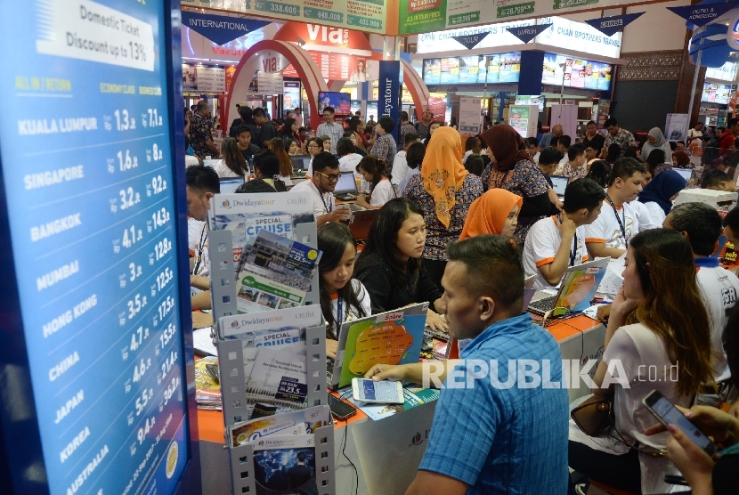 Pengunjung mencari info pemesanan tiket pada pameran Garuda Indonesia Travel Fair (GATF) di Jakarta Convention Centre, Jakarta, Jumat (22/9).