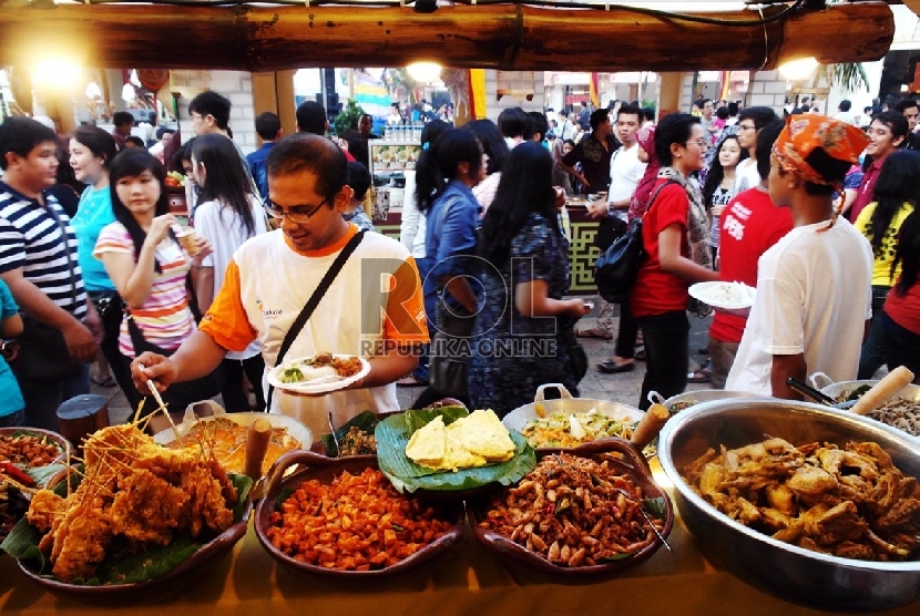 Pengunjung mencicipi salah satu makanan di kedai Jakarta Fashion & Food Festival yang rutin diselenggarakan tiap tahun di Kelapa Gading.