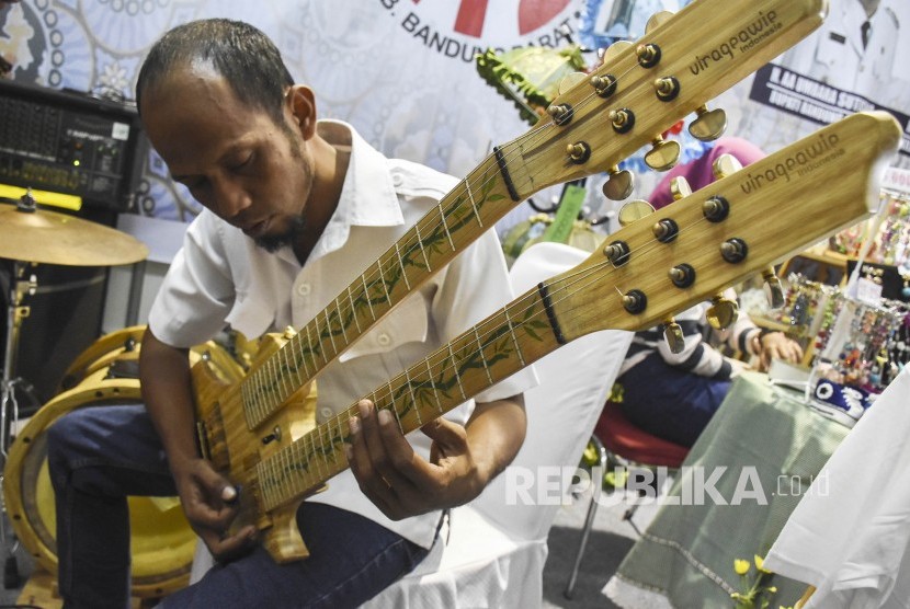 Pengunjung mencoba alat musik gitar berbahan bambu di Virageawie Indonesia pada Pameran UMKM  (ilustrasi).