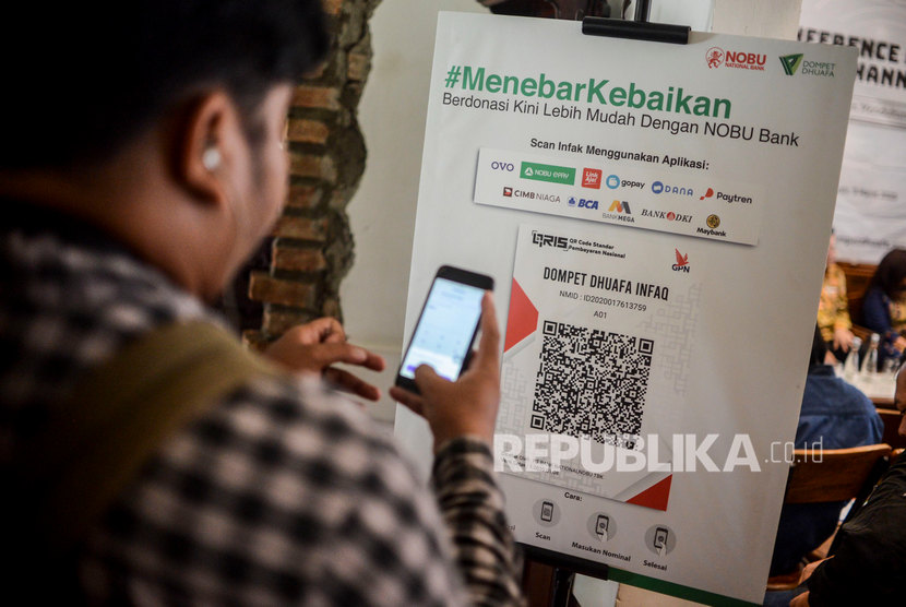 Pengunjung mencoba berzakat menggunakan teknologi QRIS di Jakarta, Senin (9/3). Dana LAZ yang ada di perbankan tercatat naik 12,8 persen.