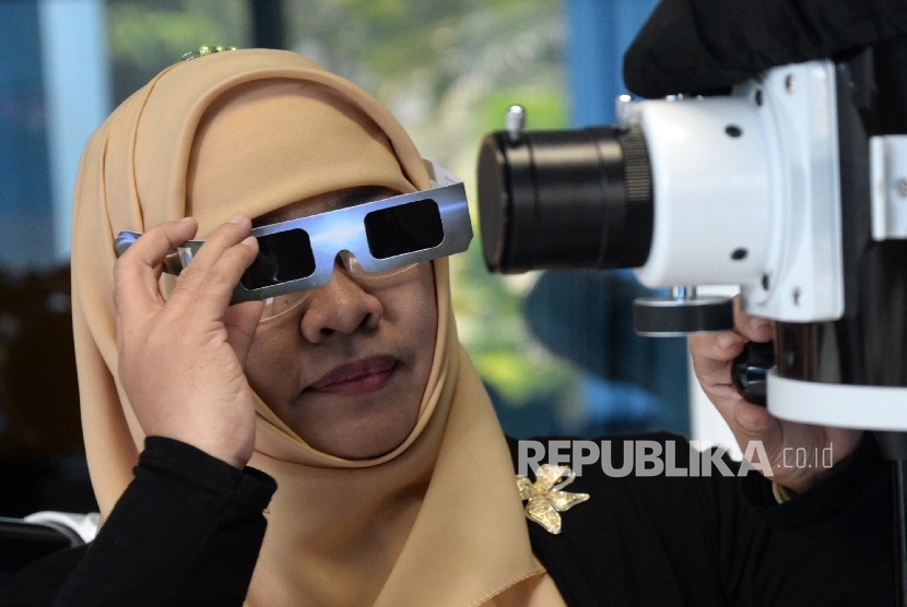 Pengunjung mencoba kacamata dan teleskop untuk melihat gerhana matahari di Planetarium dan Observatorium, Taman Ismail Marzuki (TIM), Jakarta, Senin (7/3). (Republika/Yasin Habibi)