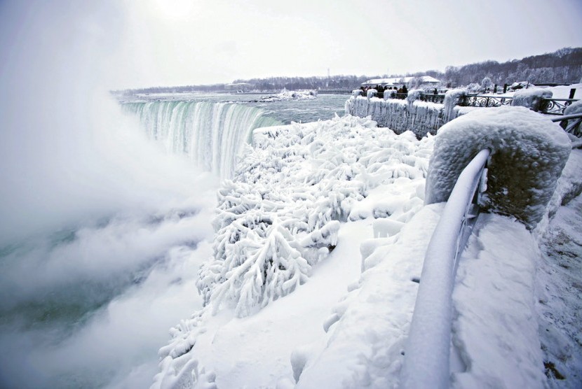 Pengunjung mengabadikan pemandangan Air Terjun Horseshoe di Air Terjun Niagara, Ontario yang membeku, Jumat (29/12).