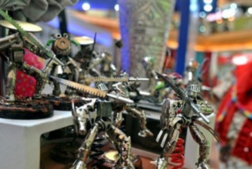 Pengunjung mengamati beberapa mainan robot hasil kerajinan tangan yang dibuat dari berbagai bahan limbah. 