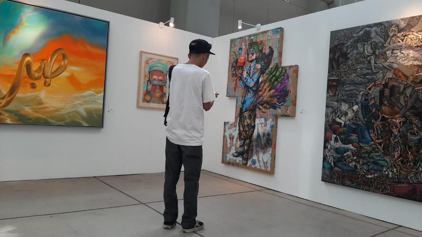 Pengunjung mengamati karya seni di pameran 