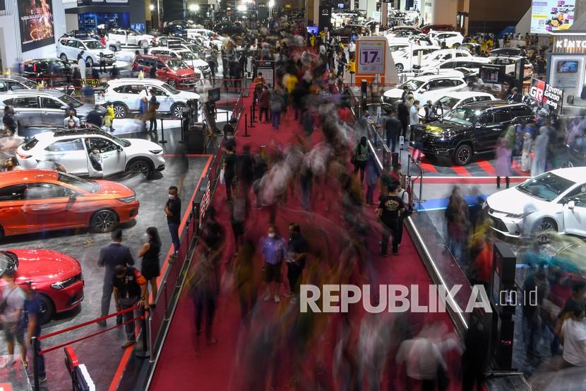 Pengunjung mengamati mobil yang dipamerkan pada Indonesia International Motor Show (IIMS) Hybrid 2022 di JIExpo Kemayoran, Jakarta, Sabtu (9/4/2022). Presiden Joko Widodo (Jokowi) mendorong industri otomotif agar meningkatkan jumlah ekspornya.