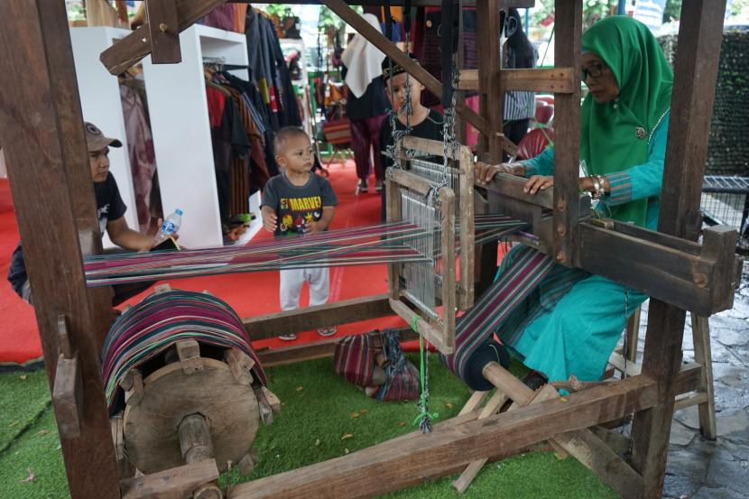 Pengunjung mengamati pembuatan kain tenun saat acara Sleman Gumyak 2020 di Wisdom Park UGM, Sleman, DI Yogyakarta.
