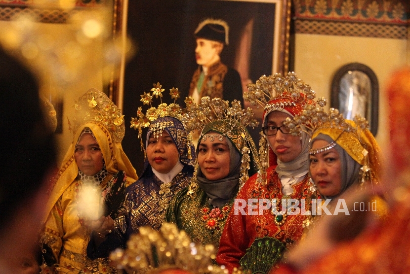 Pengunjung mengenakan pakaian adat melayu berfoto di dalam Istana Maimun, Medan, Sumatera Utara, Kamis (28/4).Republika/Rakhmawaty La'lang