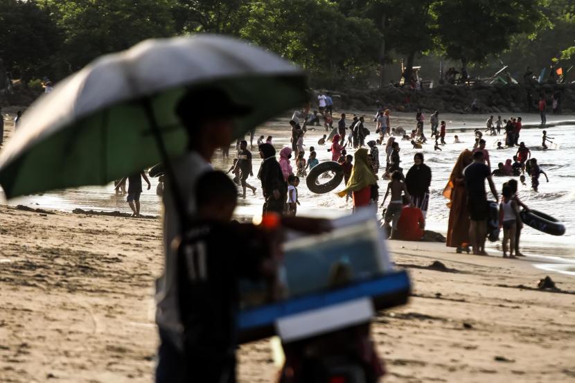 Pengunjung menikmati liburan di kawasan objek wisata pantai Ujong Blang, Lhokseumawe, Aceh, Rabu (27/5/2020). Ramainya pengunjung wisata pantai yang tidak memerhatikan protokol kesehatan seperti menjaga jarak dan memakai masker itu berisiko menambah penyebaran wabah COVID-19.