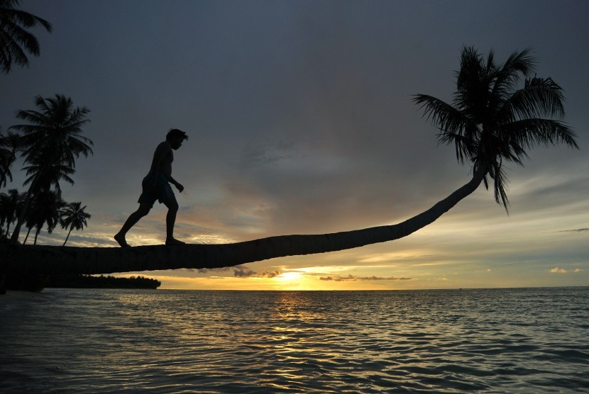 Pengunjung menikmati matahari terbenam di Pantai Mapadegat, Mentawai, Sumatra Barat. 