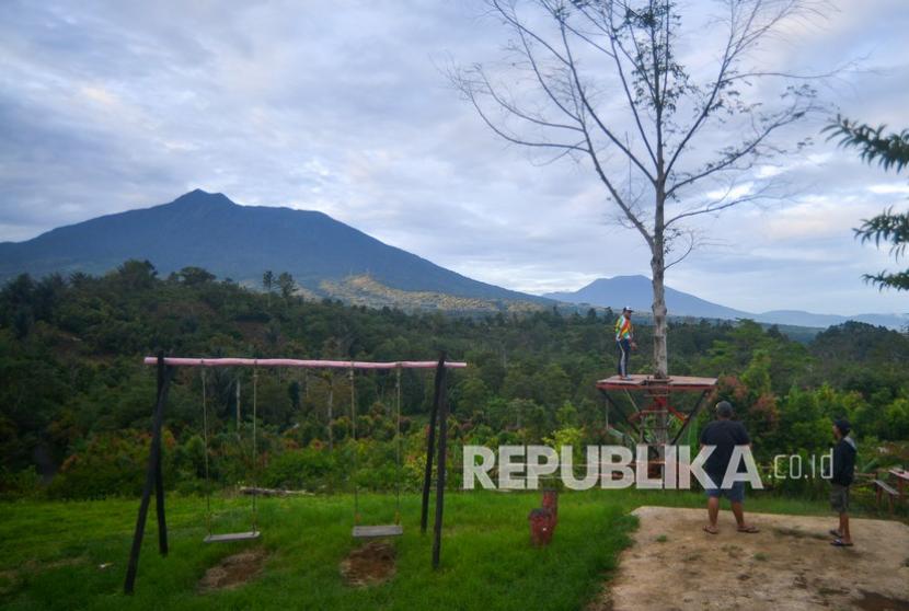 Pengunjung menikmati panorama Gunung Marapi dan Gunung Singgalang dari Puncak Data, Baso, Kabupaten Agam, Sumatera Barat. 