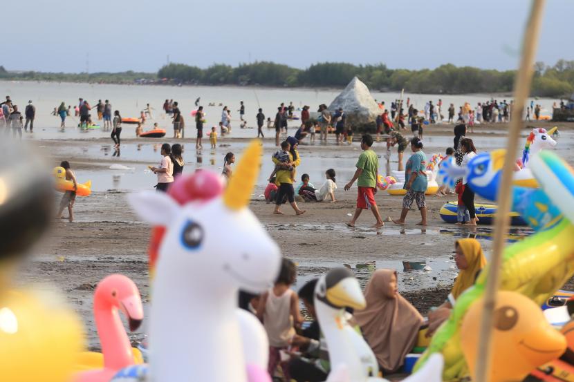 Pengunjung menikmati suasana liburan di pantai Karangsong, Indramayu, Jawa Barat, Sabtu (1/1/2022). 
