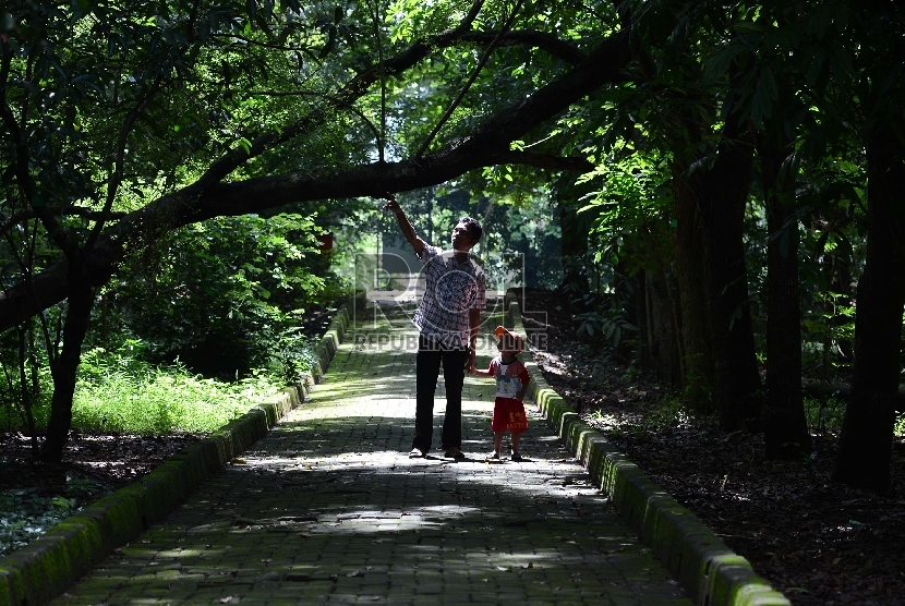 Seorang ayah bersama anaknya menikmati suasana Hutan Kota Srengseng, di Pengumben, Jakarta Barat, Kamis (12/3).  (Republika/Raisan Al Farisi)