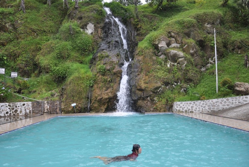 Pengunjung menikmati wisata air terjun yang dirancang dengan kolam renang di desa Parsaoran Sibisa, Kabupaten Toba Samosir, Sumatera Utara, Sabtu (4/5/2019). 