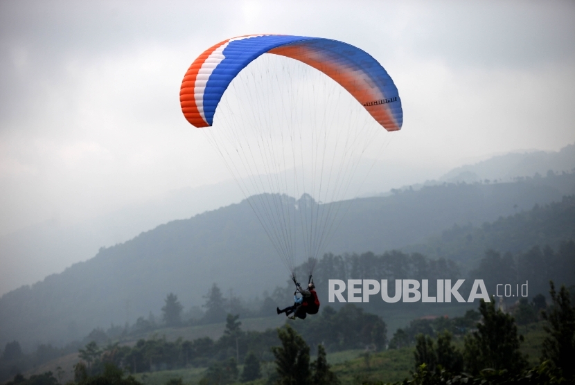   Pengunjung menikmati wisata Paralayang di kawasan Puncak, Bogor, Jawa Barat, Sabtu (9/7). (Republika/Rakhmawaty La'lang)