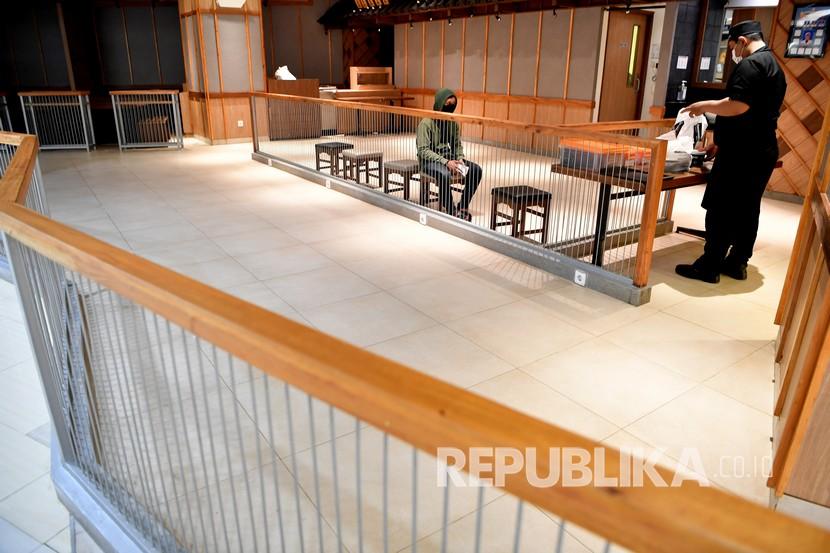 Pengunjung menunggu pesanan di salah satu restoran di pusat perbelanjaan Tunjungan Plaza, Surabaya, Jawa Timur, Jumat (29/5/2020). Sejumlah aturan protokol kesehatan seperti penggunaan masker, pemeriksaan suhu tubuh dan jaga jarak diterapkan di pusat perbelanjaan tersebut seiring memasuki era normal baru di tengah pandemi COVID-19.