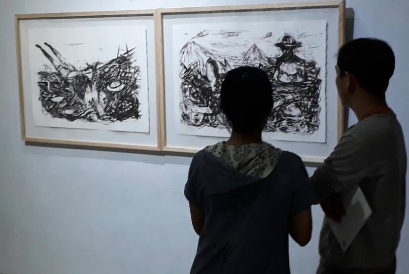 Pengunjung menyaksikan karya grafis lithografie Sri Maryanto, Bentara Budaya Yogyakarta, Sabtu (13/5).