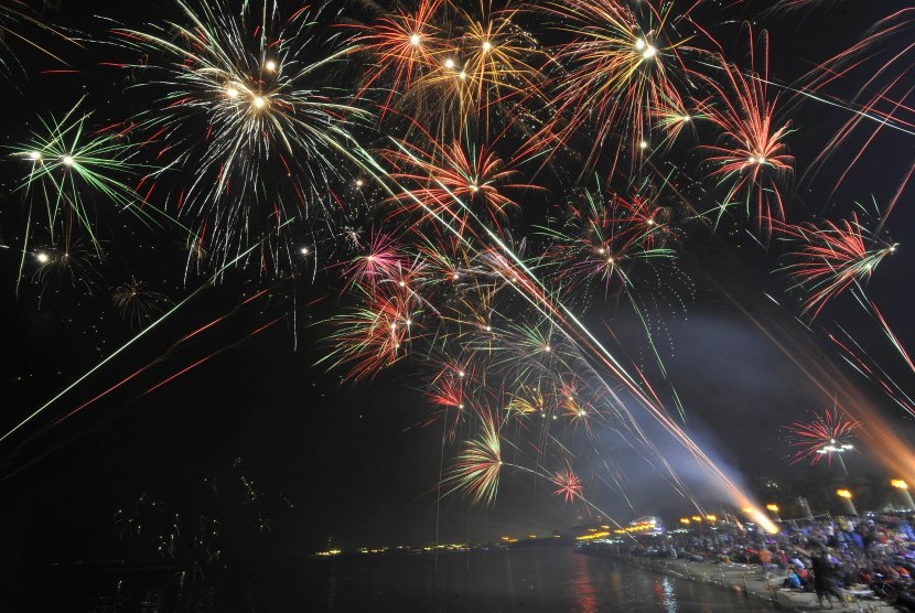 Pengunjung menyaksikan pesta kembang api perayaan malam pergantian tahun di Pantai Ancol, Jakarta.