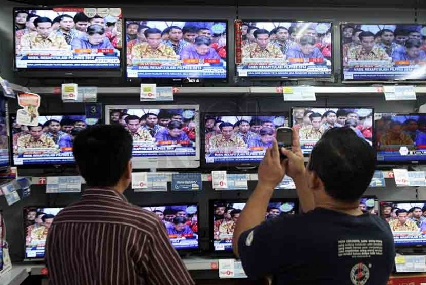 Pengunjung sebuah pusat perbelanjaan di Jakarta memotret suasan rekapitulasi nasional Pilpres 2014 KPU di layar televisi, Selasa (22/7)