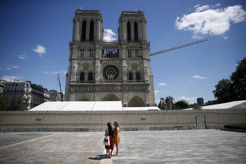 Pengunjung tampak berdiri di Alun-alun Notre Dame, Ahad (31/5), di Paris, Prancis. Alun-alun Notre Dame akhirnya dibuka kembali setelah kebakaran setahun lalu.
