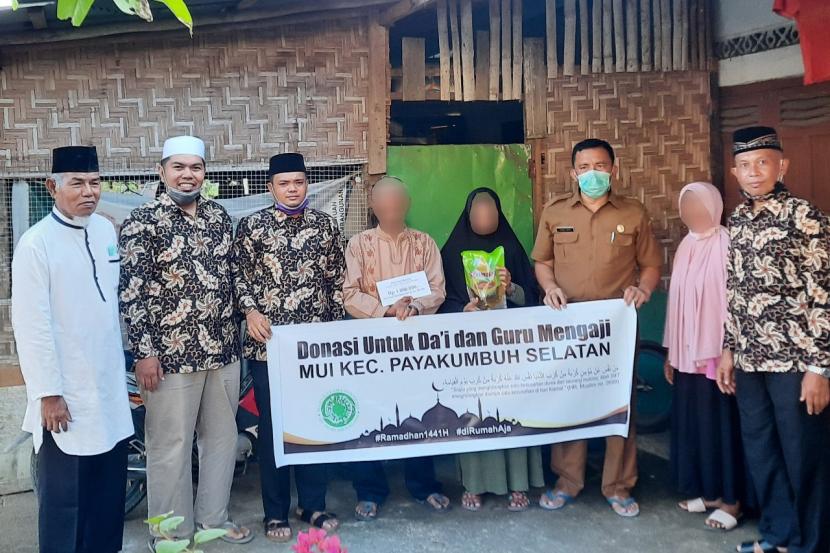 Pengurus MUI Kecamatan Payakumbuh Selatan, Sumatera Barat, menyerahkan  bantuan uang tunai dan paket sembako untuk dai dan nguru mengaji.