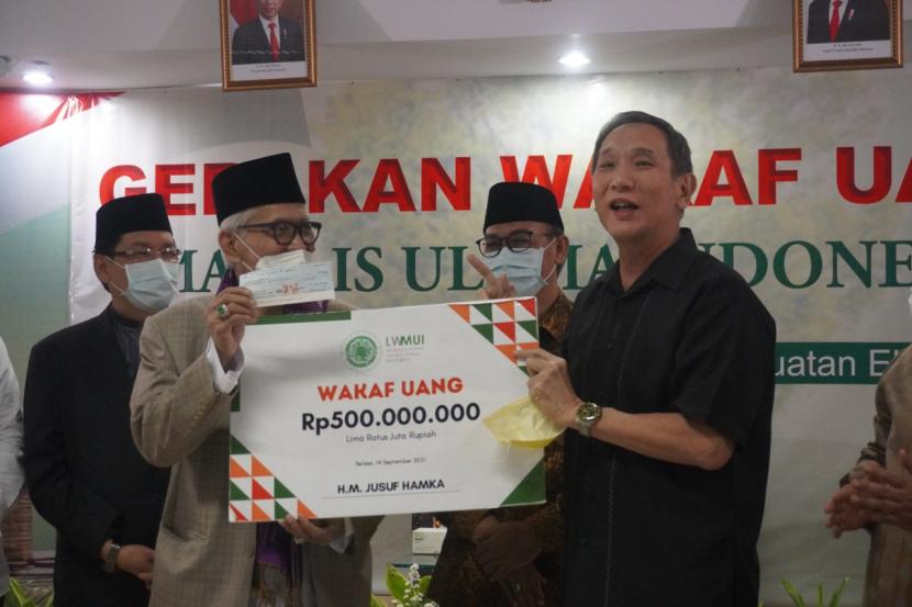 Pengusaha nasional Muhammad Jusuf Hamka menyerahkan wakaf senilai Rp 500 juta kepada Lembaga Wakaf Majelis Ulama Indonesia (LWMUI)  pada acara Gerakan Wakaf Uang MUI untuk Dakwah dan Penguatan Ekonomi Umat, di Gedung MUI Jakarta,  Selasa (14/9).