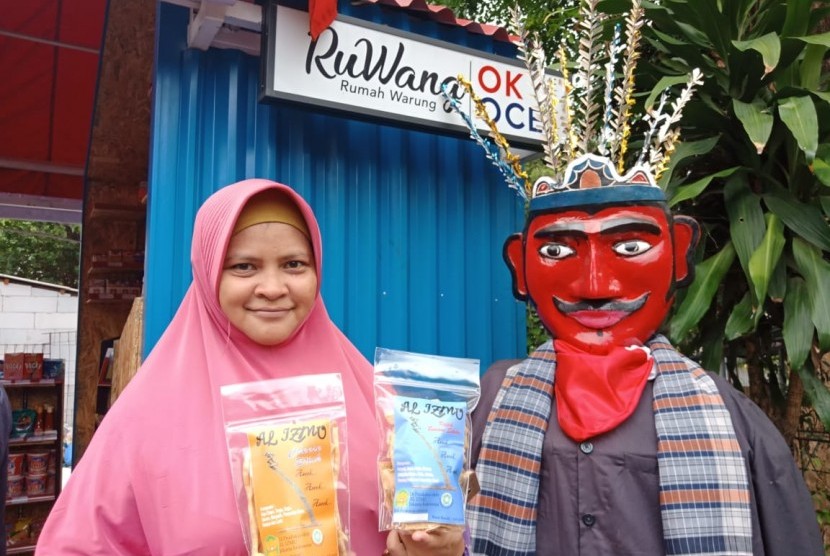 Pengusaha Rumahan Binaan OK OCE Siti Rosidah (34) berpose di depan Rumah Warung (RuWang) Kelurahan Cipete Utara, Rabu (24/11). Dalam pose tersebut Siti nampak memamerkan produk makanan rumahannya.