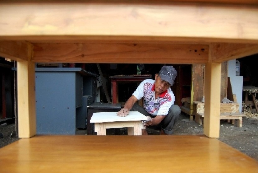 Pengusaha UKM, Yajid (52) mengamplas meja belajar yang akan dijual di rumah produksi miliknya kawasan Lenteng Agung, Jakarta Selatan, Kamis (26/6).