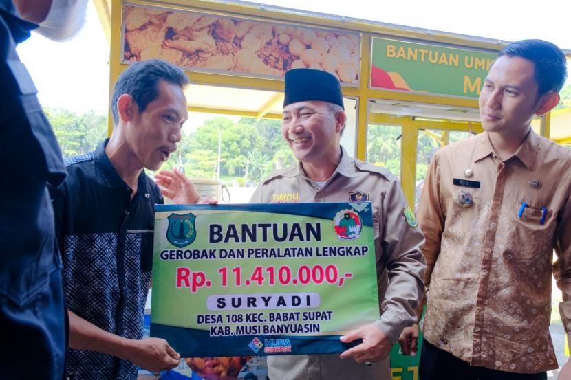 Penjabat Bupati Musi Banyuasin Drs H Apriyadi MSi saat memberikan bantuan untuk UMKM Muba di Halaman Kantor Camat Babat Supat, Kamis (15/9/2022). 