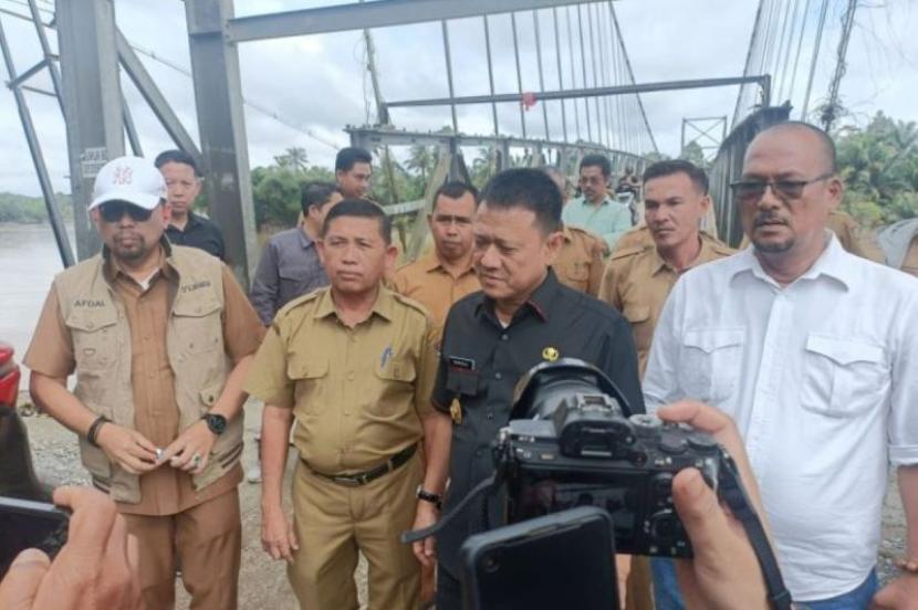 Penjabat (Pj) Bupati Kampar Hambali saat meninjau kondisi jembatan gantung dan abrasi Sungai Kampar, di Desa Gobah, Kecamatan Tambang, Kampar, Riau, Selasa (16/1/2024).