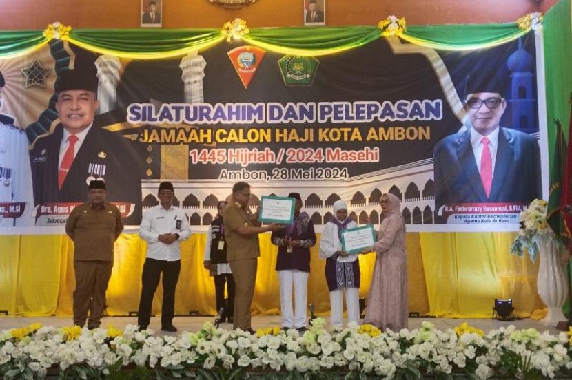 Penjabat Wali Kota Ambon Dominggus Kaya saat menyerahkan tambahan bantuan uang saku kepada perwakilan calon jamaah haji Kota Ambon saat pelepasan di Ambon, Selasa (28/5/2024). 
