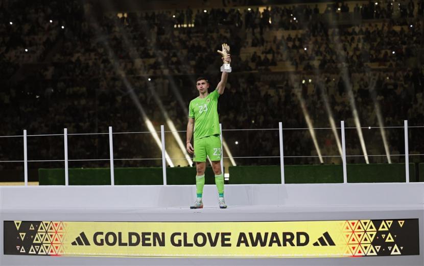  Penjaga gawang Argentina Emiliano Martinez berpose setelah menerima penghargaan Golden Glove sebagai kiper terbaik turnamen setelah kalah di Final Piala Dunia FIFA 2022 antara Argentina dan Prancis di stadion Lusail di Lusail, Qatar,  Ahad (18/12/2022).