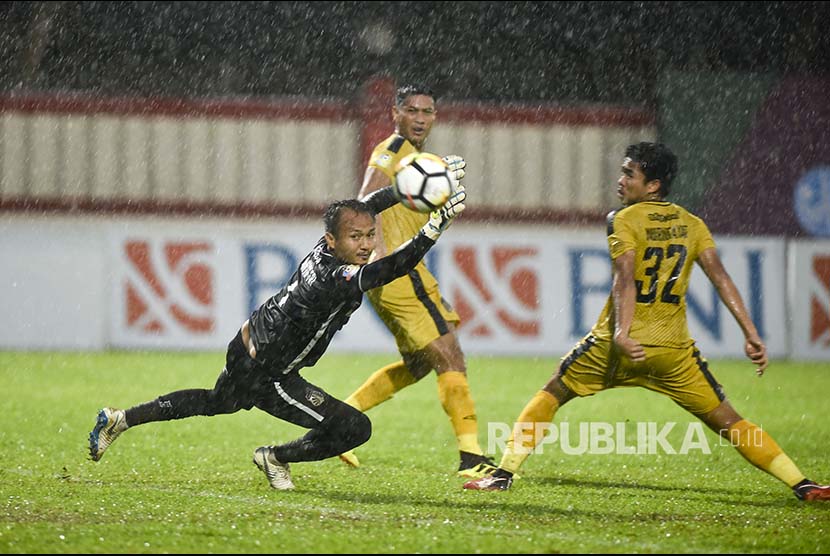 Penjaga gawang Bhayangkara FC Wahyu Tri Nugroho (kiri) berusaha menangkap bola dari pesepak bola Persib Bandung dalam pertandingan Liga 1 2018 di Stadion PTIK, Jakarta, Sabtu (3/11).