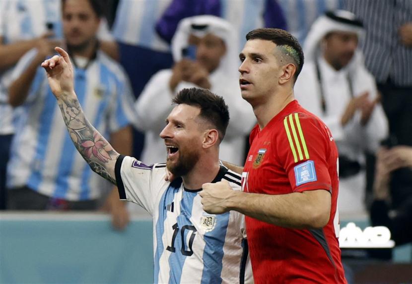  Penjaga gawang timnas Argentina Emiliano Martinez (kanan) bereaksi dengan Lionel Messi. Emiliano Martinez akan mencoba membujuk  Messi untuk bergabung dengan Aston Villa.