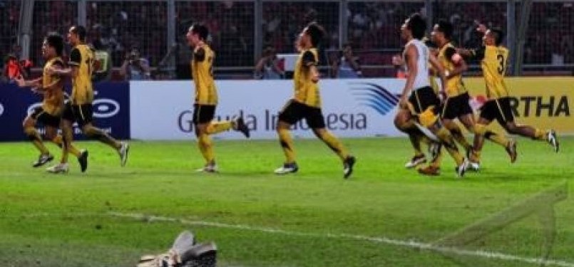 Penjaga gawang Indonesia, Kurnia Meiga, menutup wajahnya saat pemain Malaysia merayakan kemenangan mereka dalam penalti saat final sepakbola SEA Games XXVI di stadion GBK, Senayan, Jakarta, Senin (21/11). 