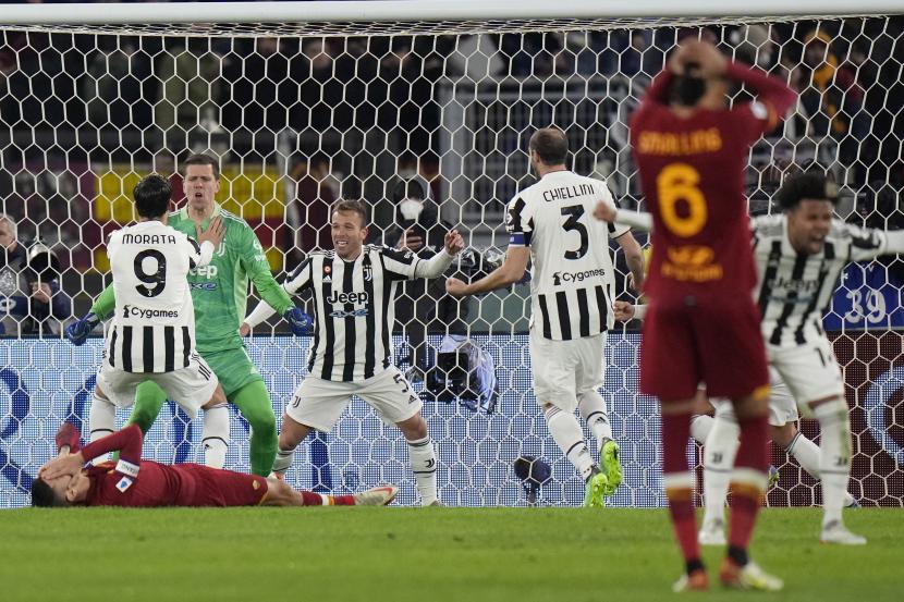  Penjaga gawang Juventus Wojciech Szczesny (kedua dari kiri) merayakan dengan rekan satu timnya setelah menggagalkan tembakan penalti pemain Roma Lorenzo Pellegrini (terbawah), selama pertandingan sepak bola Serie A Italia antara Roma dan Juventus di Stadion Olimpiade di Roma, Italia, Ahad, 9 Januari 2022. Juventus menang 4-3 atas Roma.