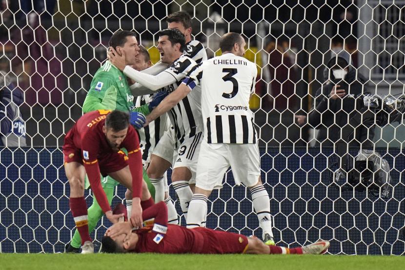 Penjaga gawang Juventus Wojciech Szczesny, kiri, merayakan dengan rekan satu timnya setelah menyelamatkan tendangan penalti oleh pemain Roma Lorenzo Pellegrini, terbawah, selama pertandingan sepak bola Serie A Italia antara Roma dan Juventus di stadion Olimpiade di Roma, Italia, Ahad 9 Januari, 2022.