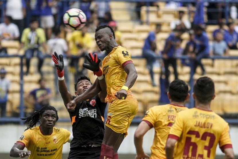 Penjaga gawang PSM Makassar Syaiful (kedua kiri) berusaha menghalau sundulan pemain Sriwijaya FC Mahamadou N'Diaye (tengah) pada laga lanjutan Grup A Piala Presiden 2018 di Stadion Gelora Bandung Lautan Api, Bandung, Jawa Barat, Ahad (21/1). Sriwijaya berhasil mengalahkan PSM dengan skor akhir 3-0. 