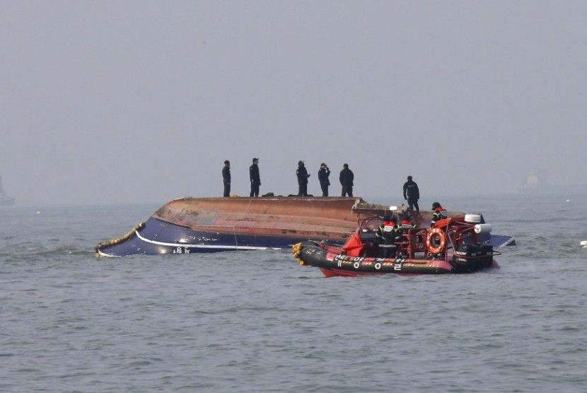 Penjaga Pantai Korea Selatan melakukan penyelamatan kapal nelayan yang terbalik setelah tabrakan dengan kapal tanker di Incheon, Korea Selatan, Ahad (3/12).